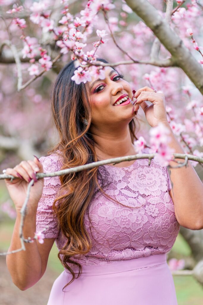 Model Riya smiles in a peach blossom orchard in Charlotte NC