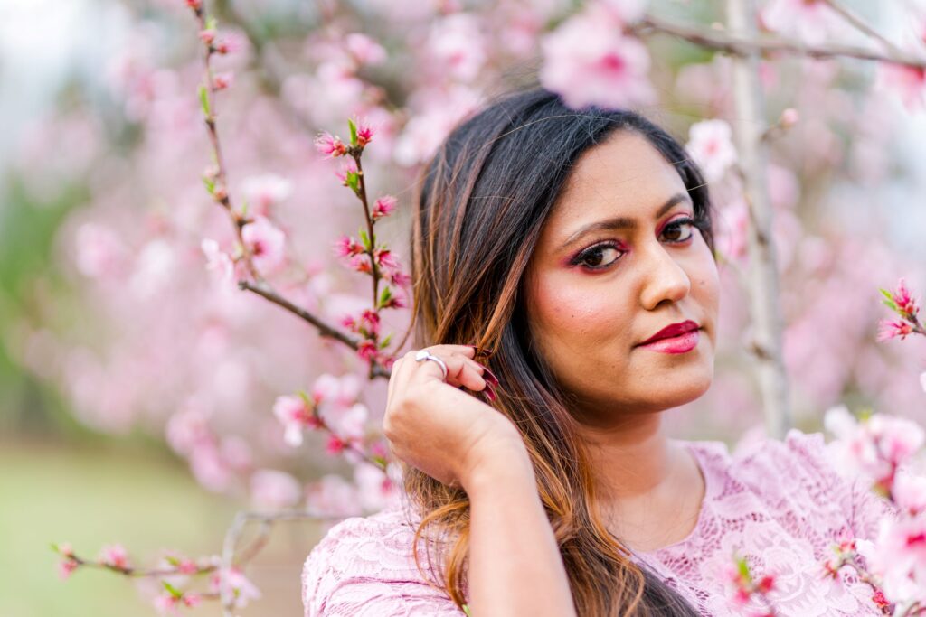 Model Riya poses in a peach blossom orchard in Charlotte NC