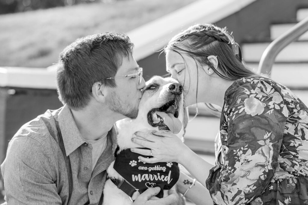 A couple kisses their dog during their engagement session in Boone NC