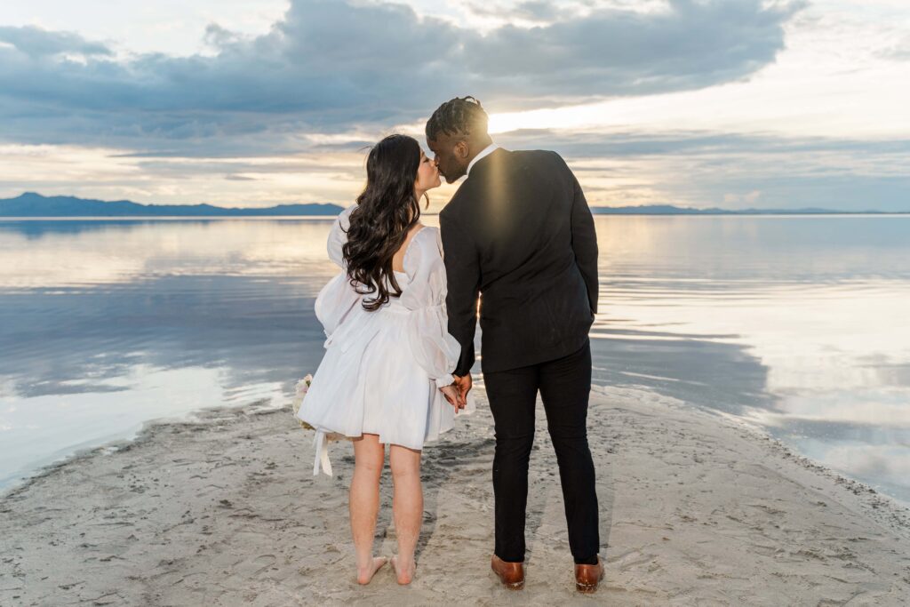 Couple walking hand in hand along the shore of Stansbury Island's pink salt lake