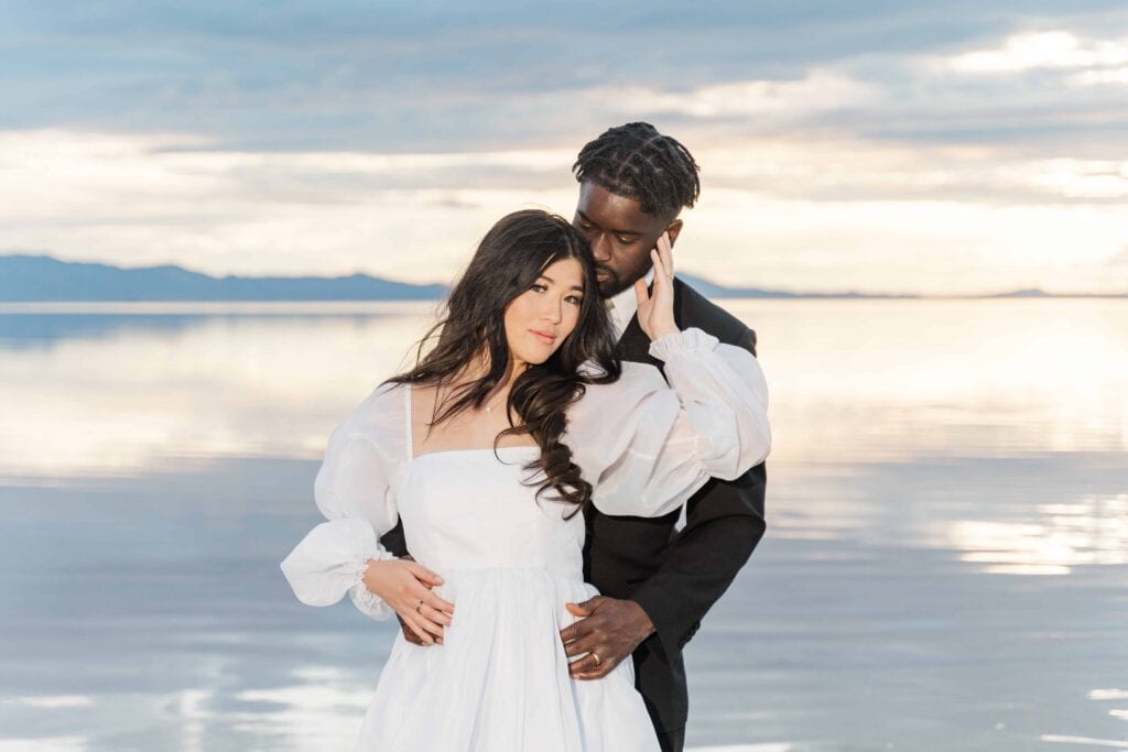 Romantic couple embraces against the pink salt lake backdrop at Stansbury Island