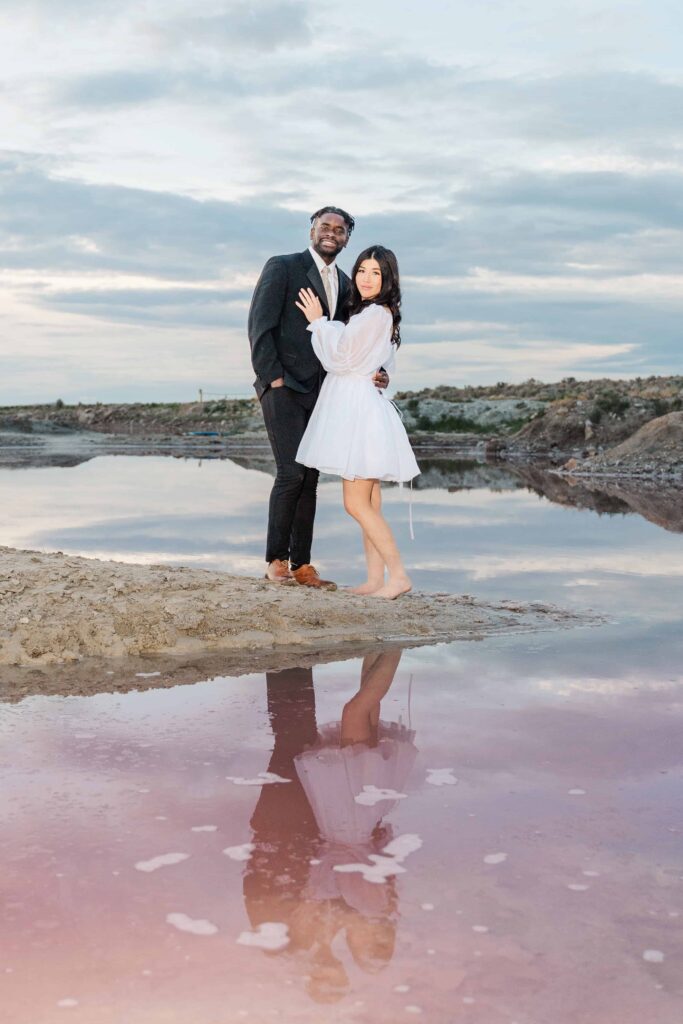 Reflection of a couple in the serene waters of Stansbury Island's pink salt lake