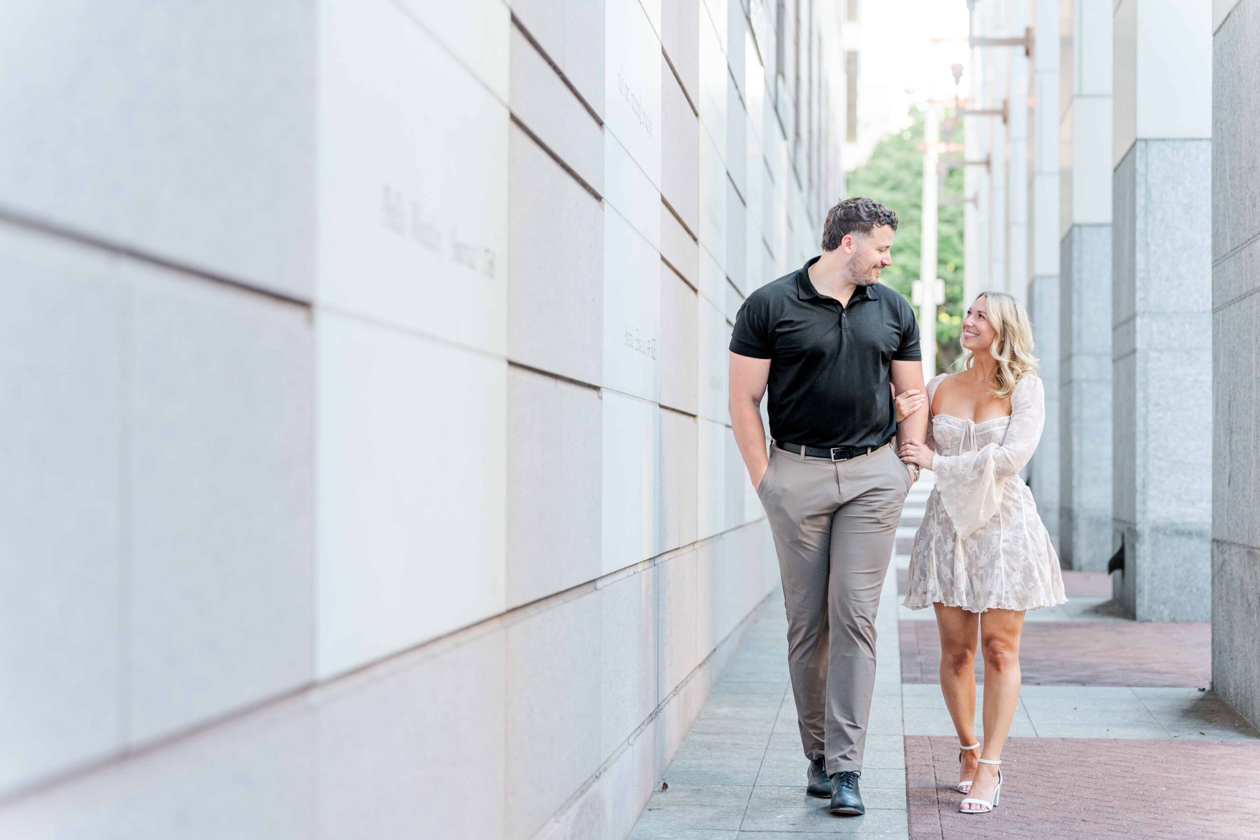 Deven and Ells walk together at the courthouse, the white and gray columns surrounding them making for a beautiful, urban backdrop for their session