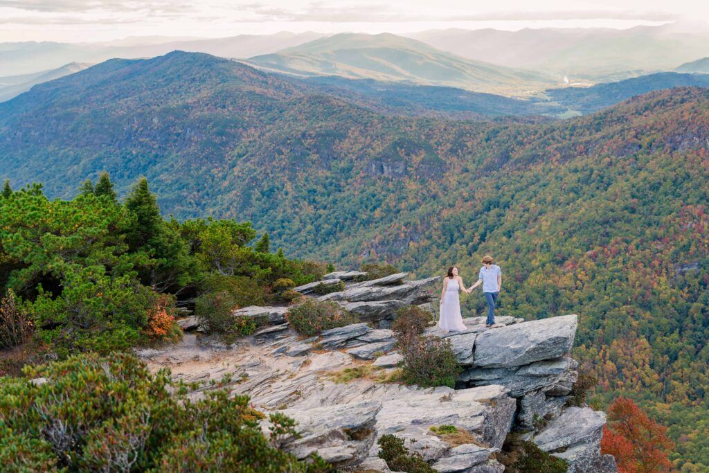 Sweeping view of Blue Ridge Mountain ridgeline with peak fall foliage under a cloudy golden hour sky.