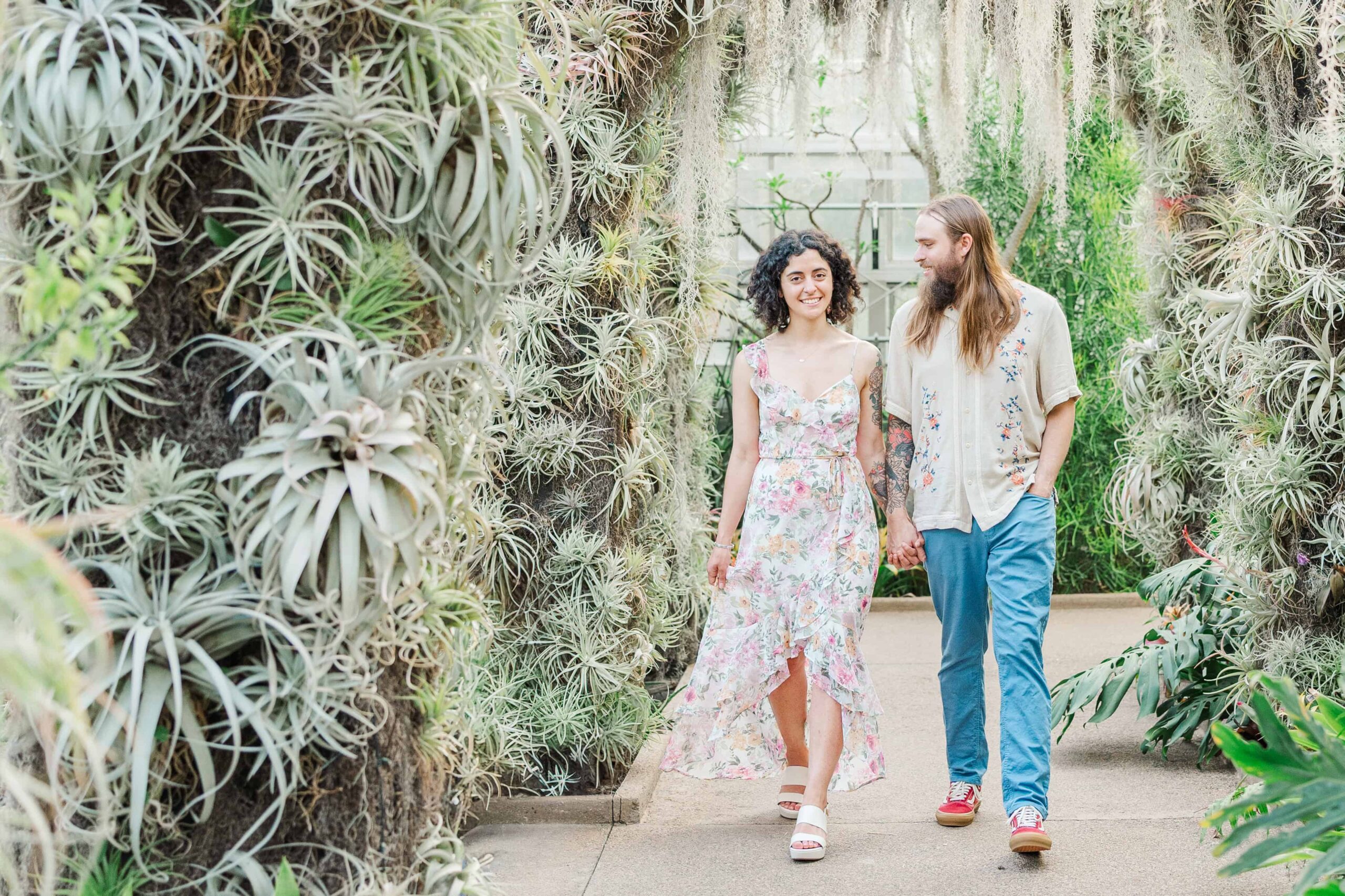 Couple walking hand-in-hand through the succulent arches in the Orchid Conservatory
