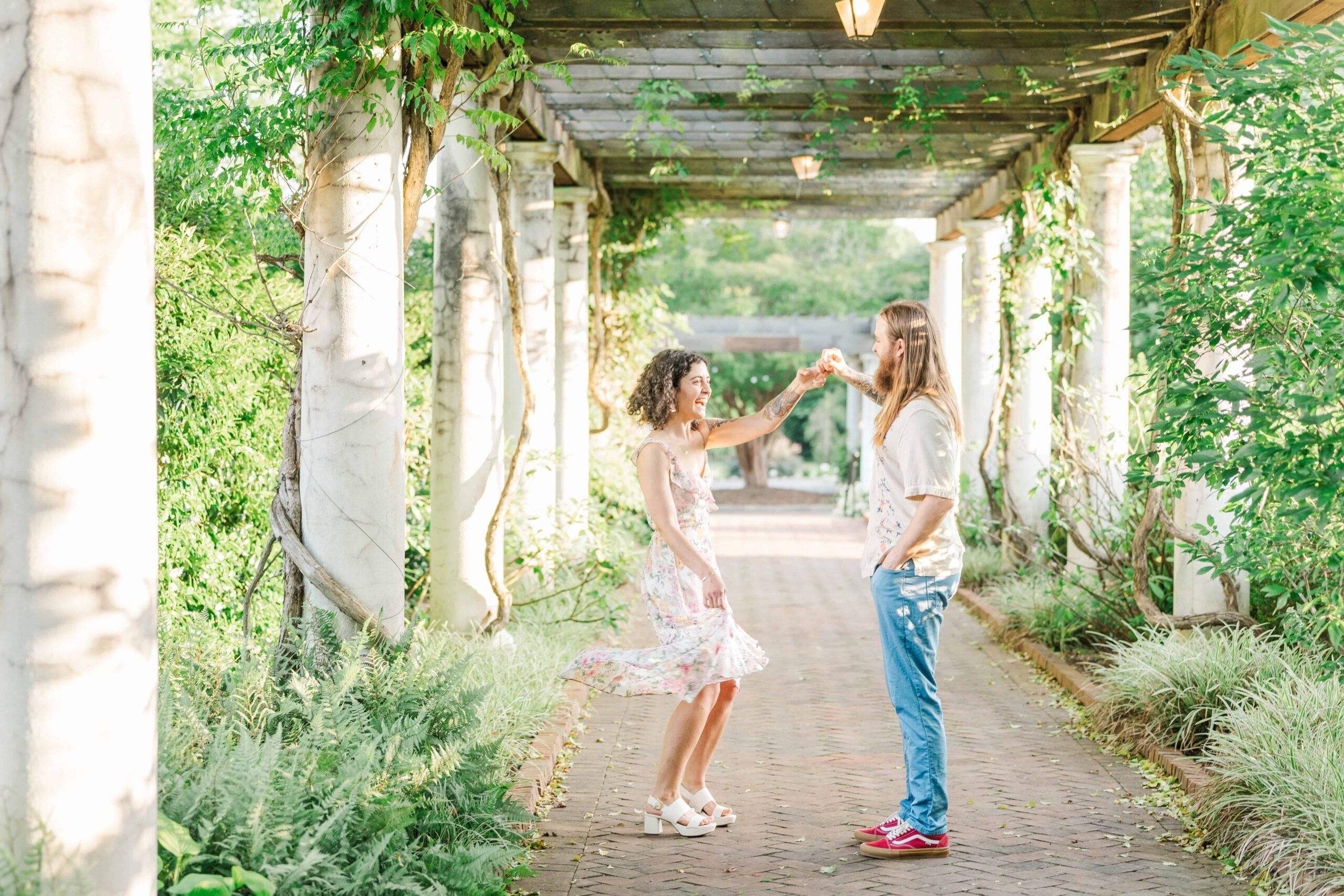 Bride-to-be spinning in garden sunlight during Four Seasons Garden session