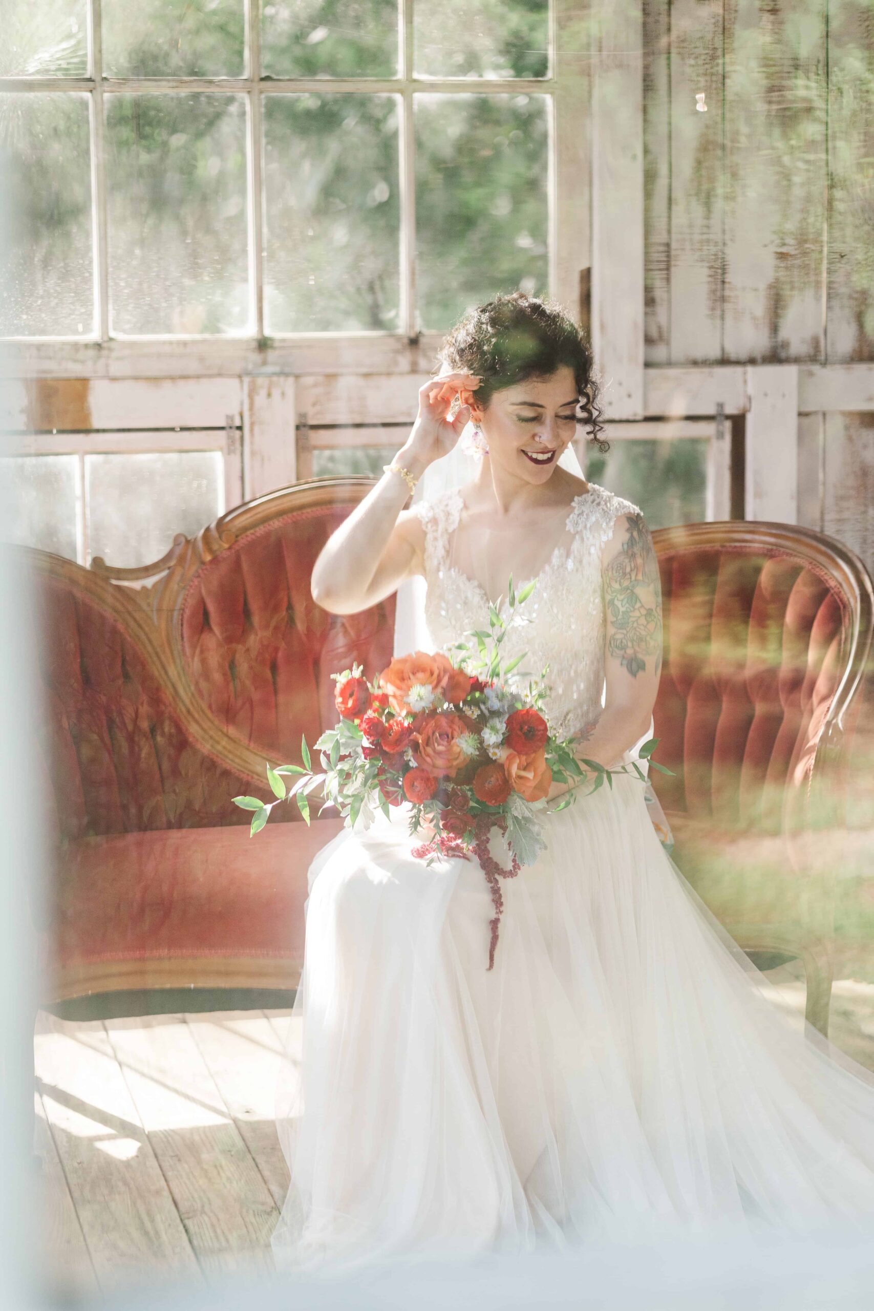 Victorian red couch in the white greenhouse at Mariposa Chapel wedding venue