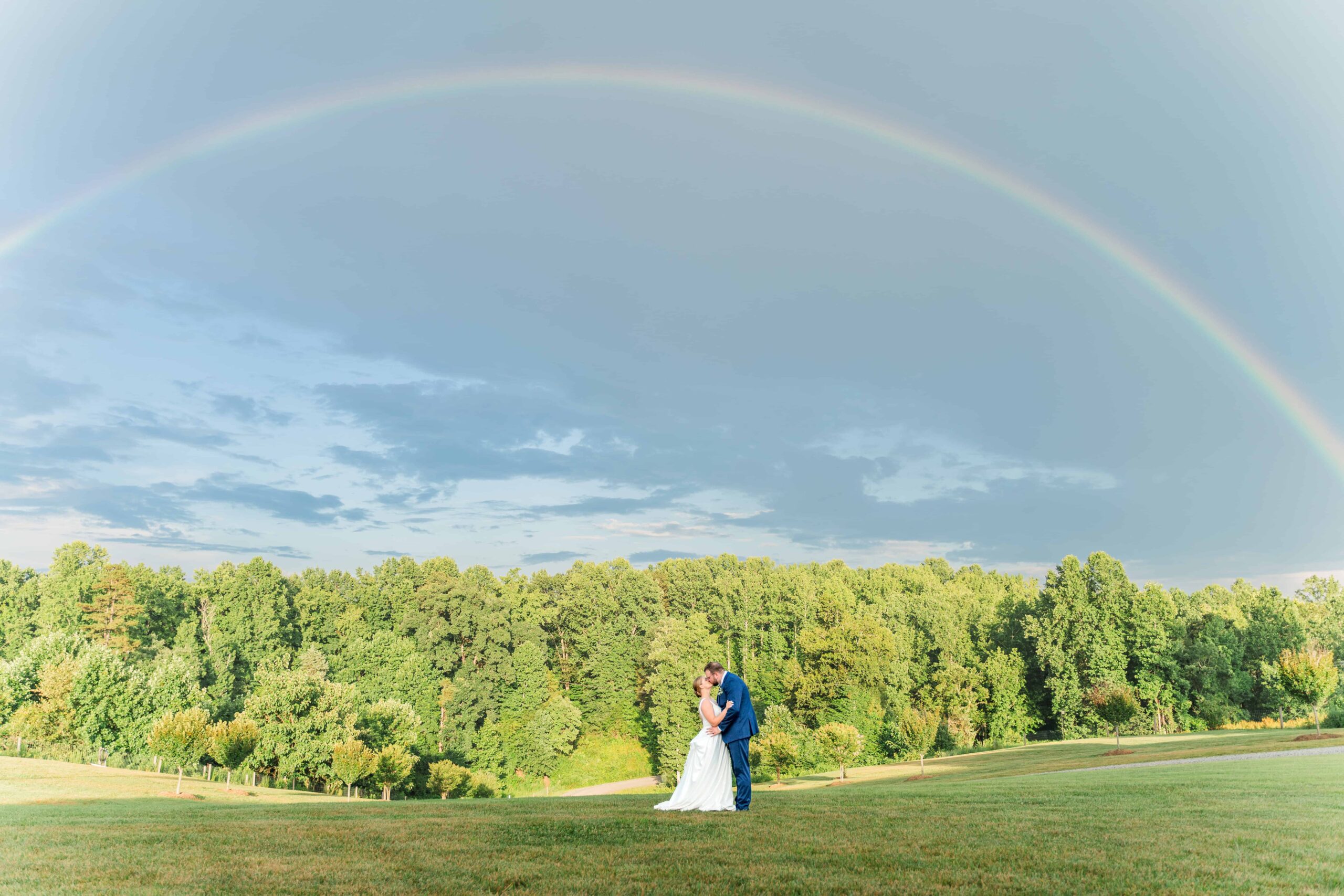 bride a groom posing under a rainbow. Make sure to prioritize photography in your wedding budget to capture images like this
