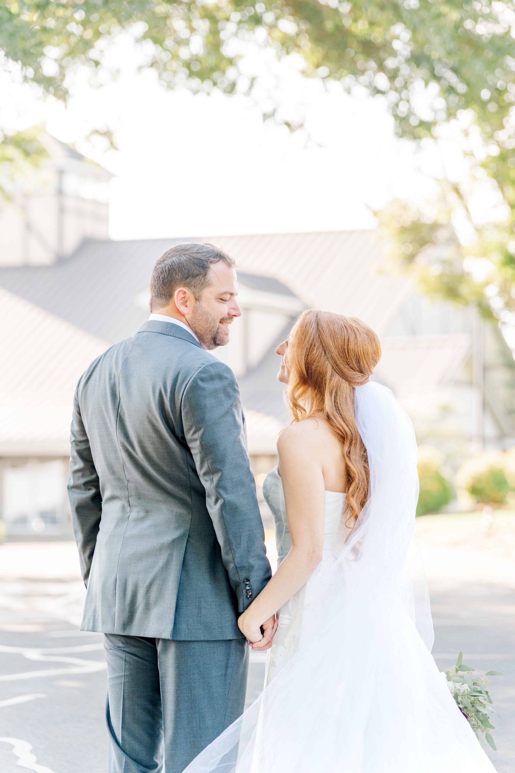 Bride and groom walking hand in hand on golf course