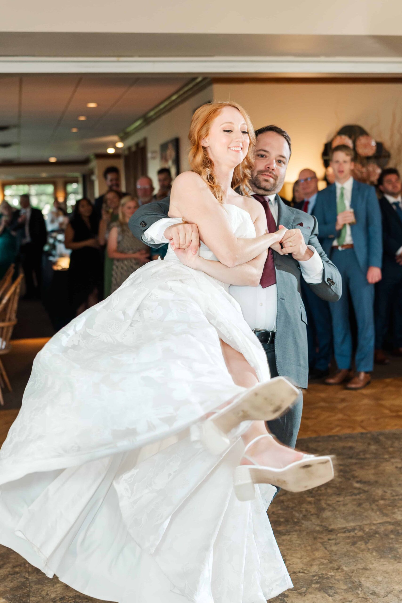 Bride lifted by groom during fun wedding dance