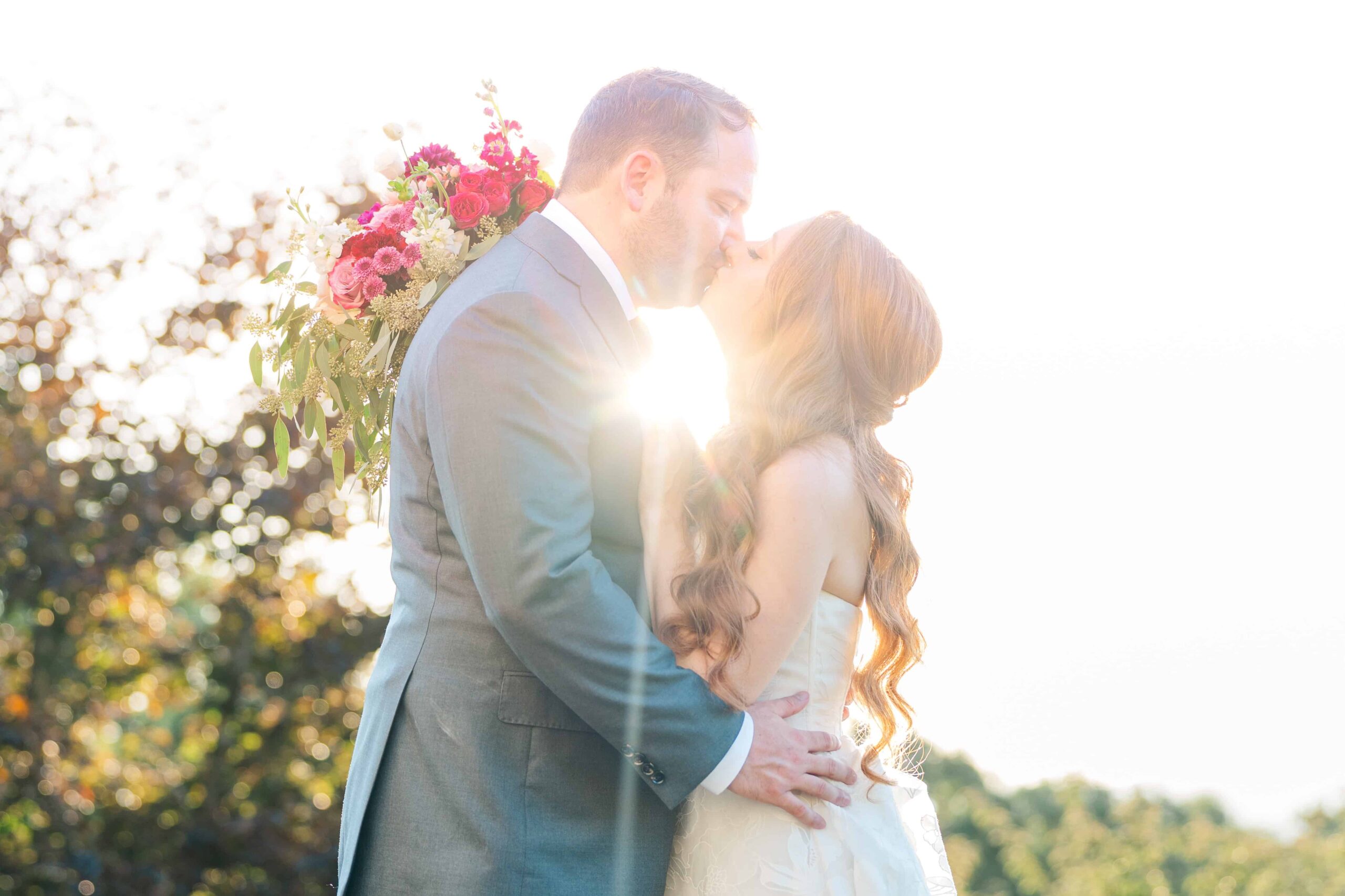 Couple kissing under panoramic mountains in Olde Beau Resort & Golf Club wedding photography