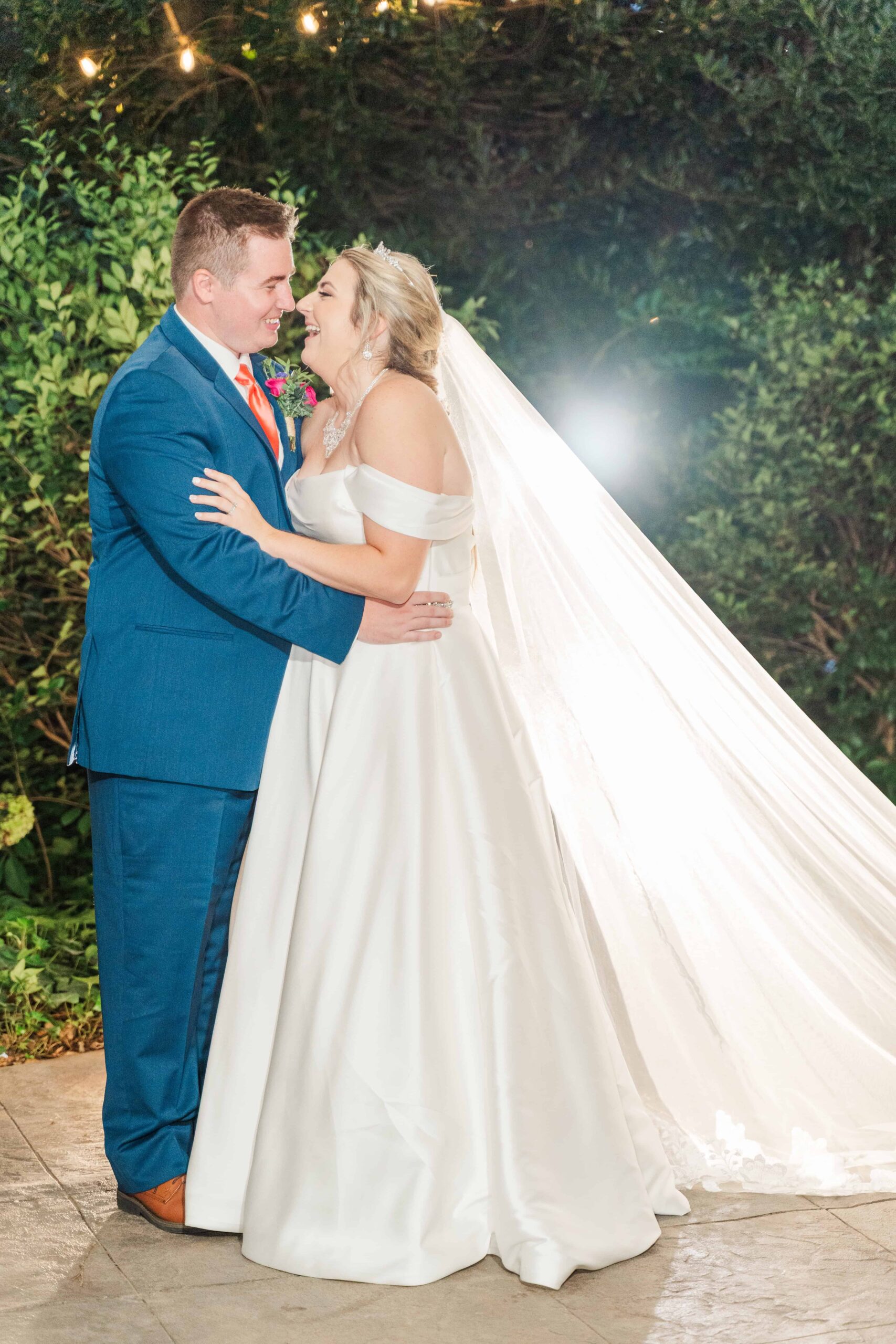 Bride and groom kissing in front of the gazebo under twinkle lights at The Grande Victorian