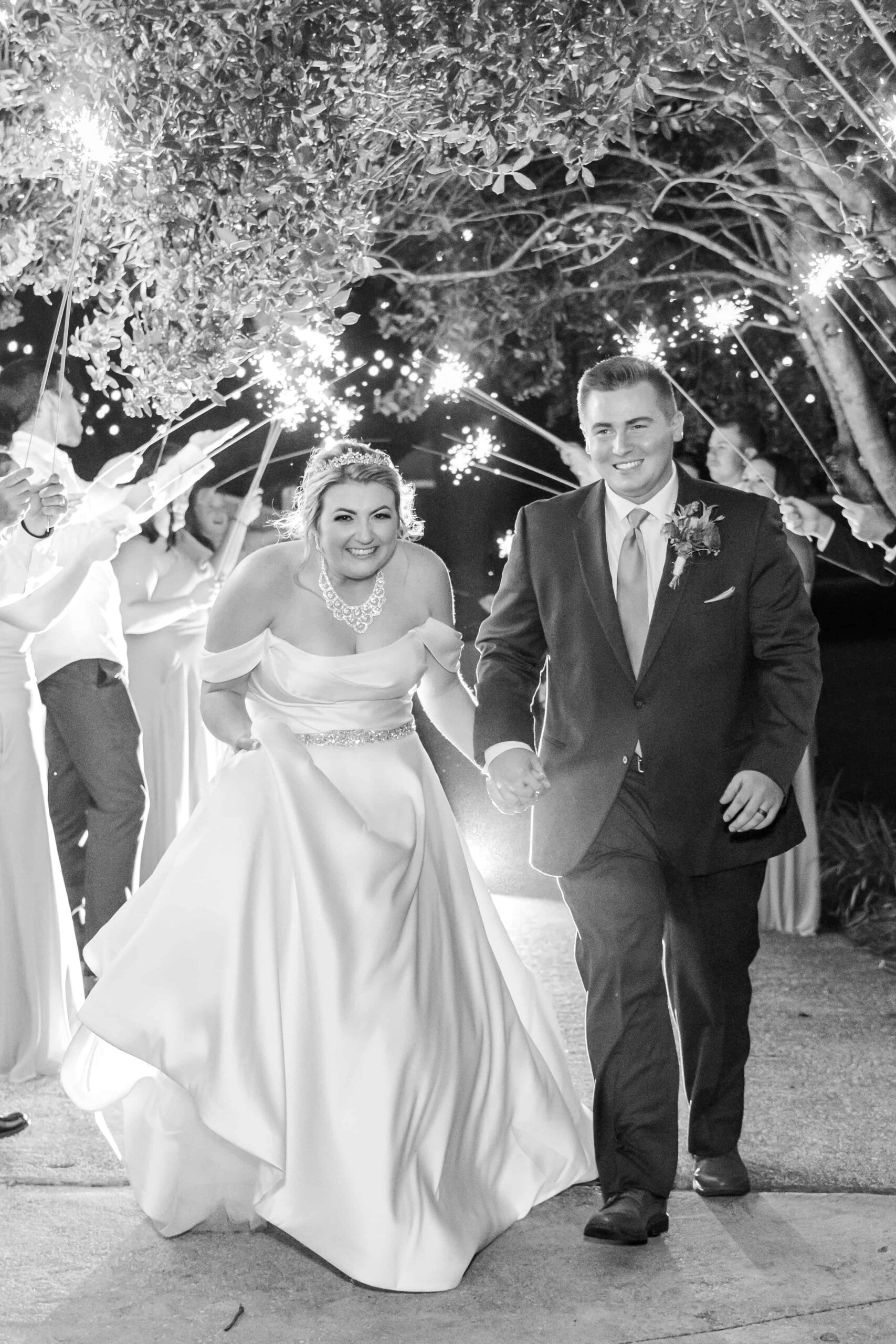 Sparkler exit with bride and groom smiling in front of the historic Victorian estate at The Grande Victorian
