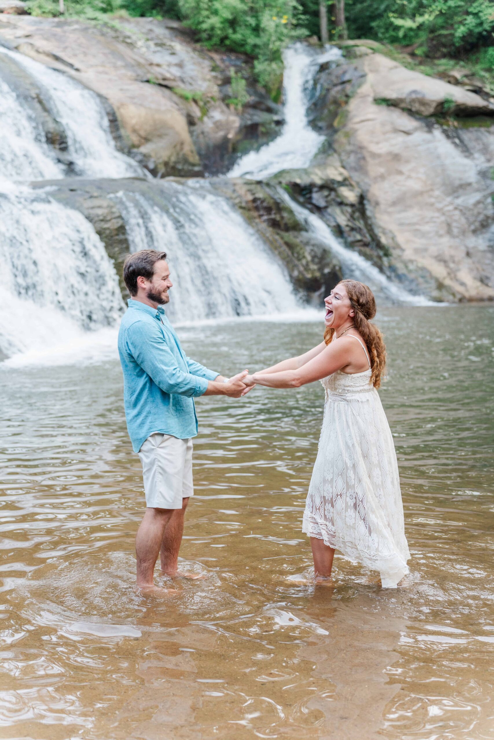 Adventure couple playing in the pool at McGalliard Falls during summer engagement session