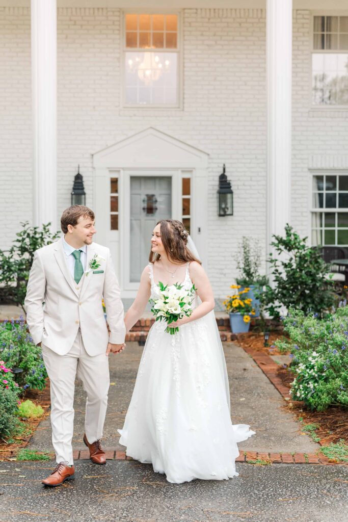 Couple walking hand in hand after wedding reception at Heron Hill Venue