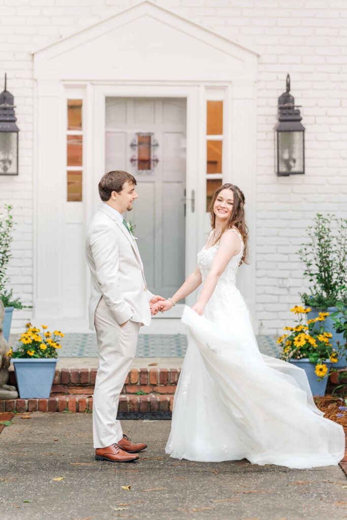 Groom twirling bride on front porch at Heron Hill Venue wedding