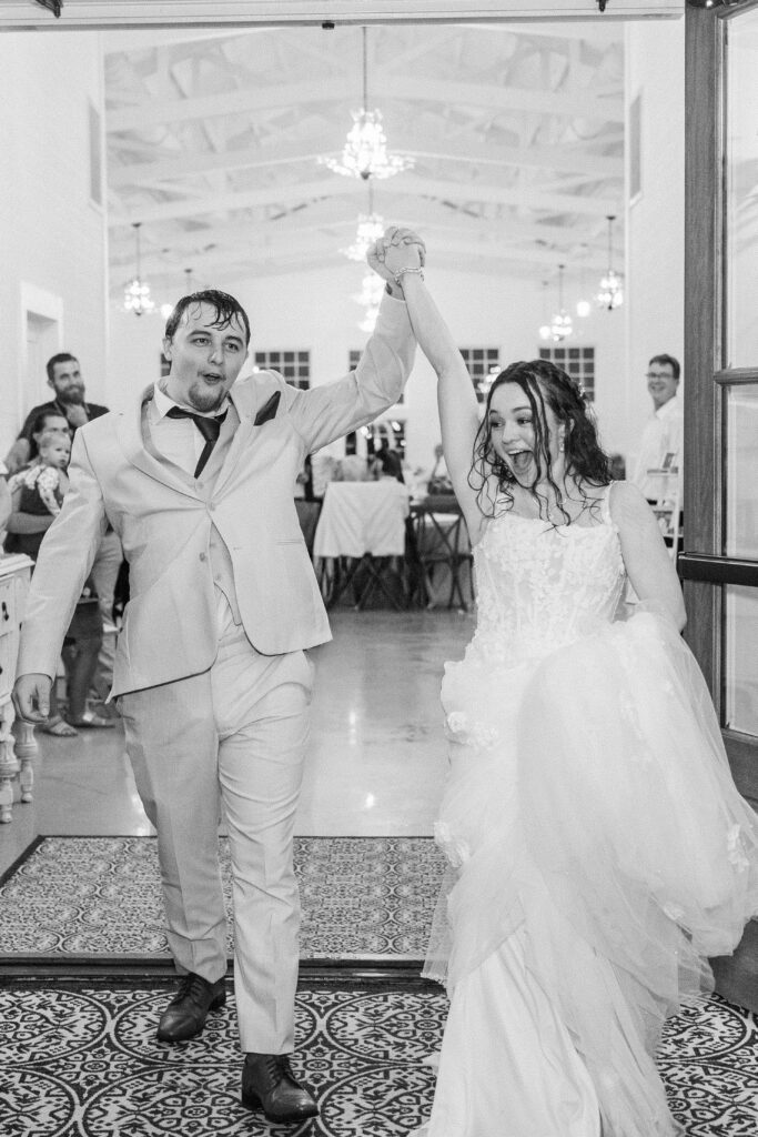 Couple cheering during rainy sparkler exit at Heron Hill Venue wedding