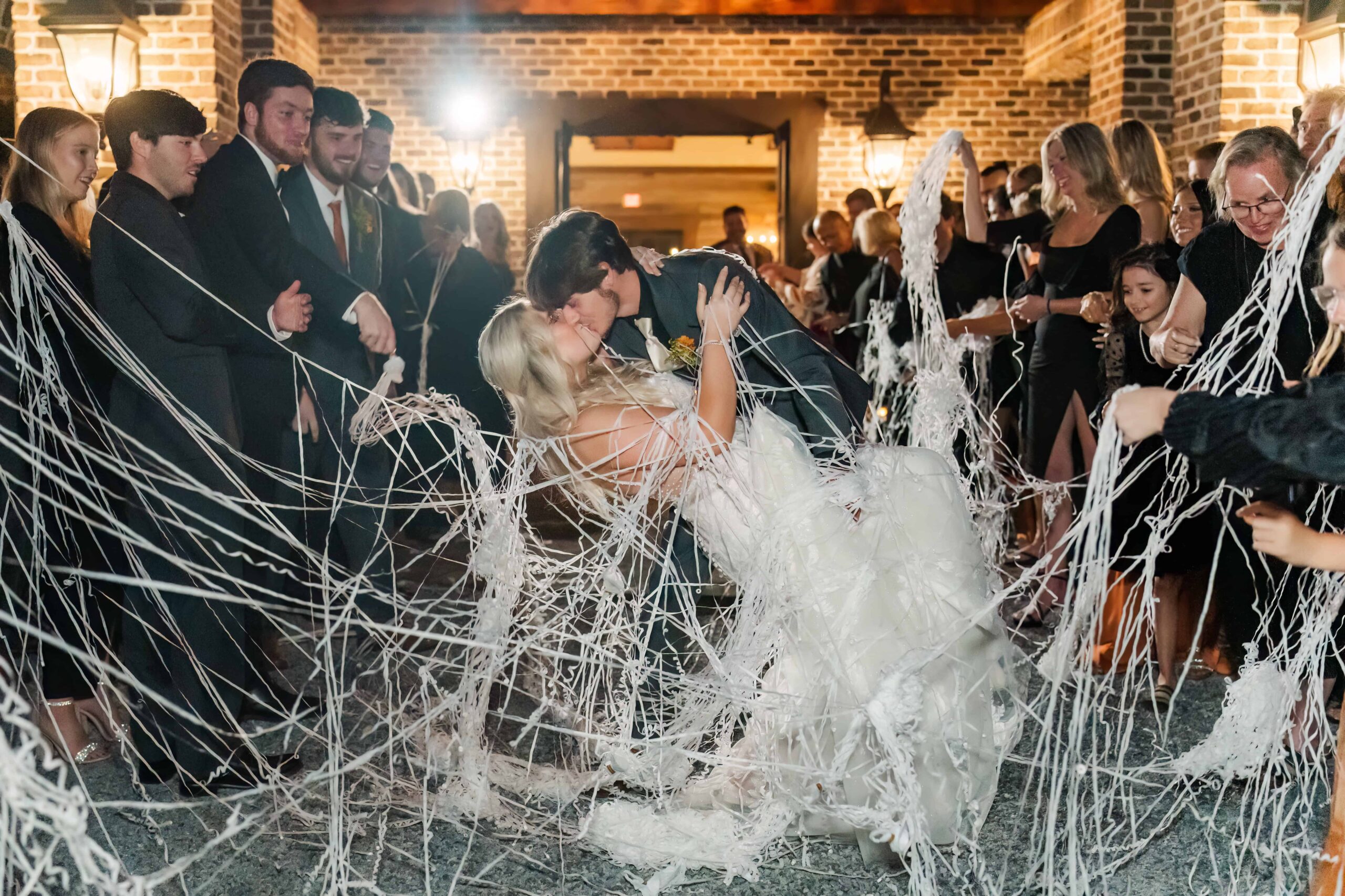 Grand exit with pop streamers covering the married couple