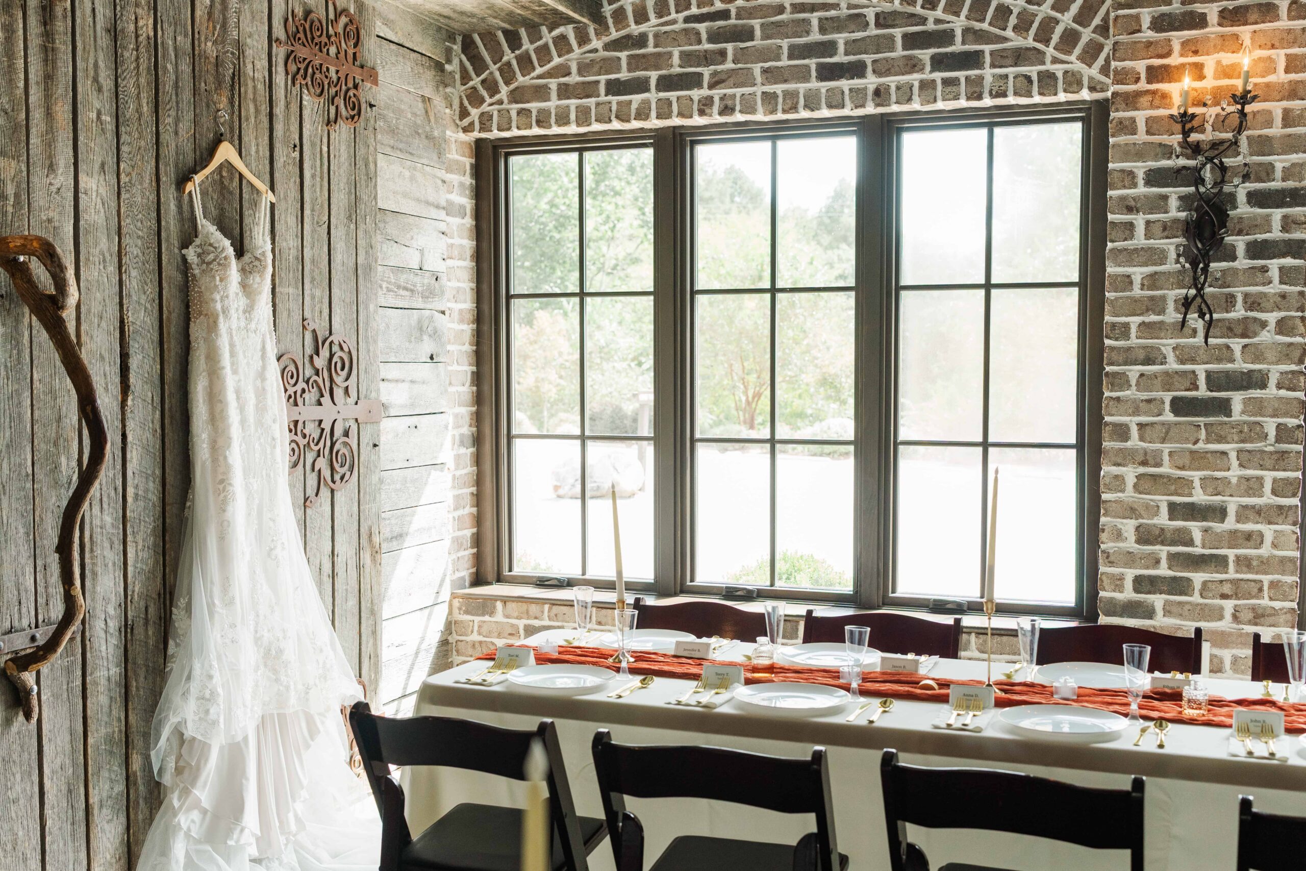 Katelyn’s bridal gown hanging on the wooden doors of Catawba Falls Events