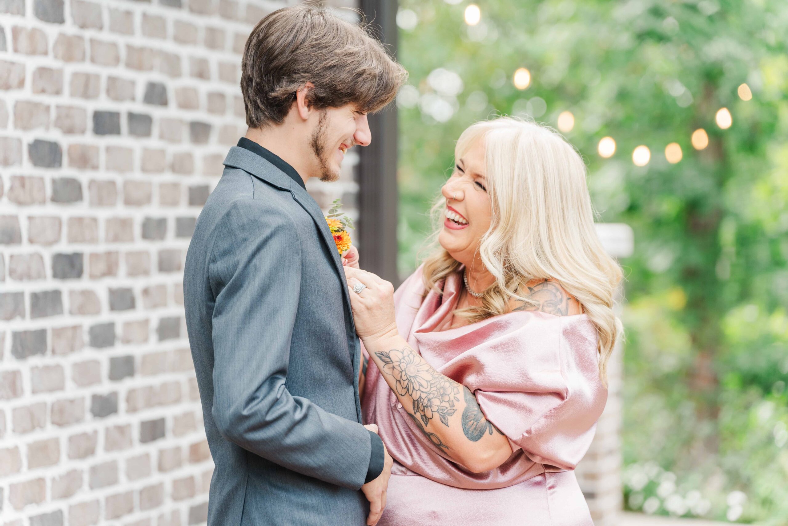 Mother of the groom putting on the groom's boutonniere at Catawaba Falls Events