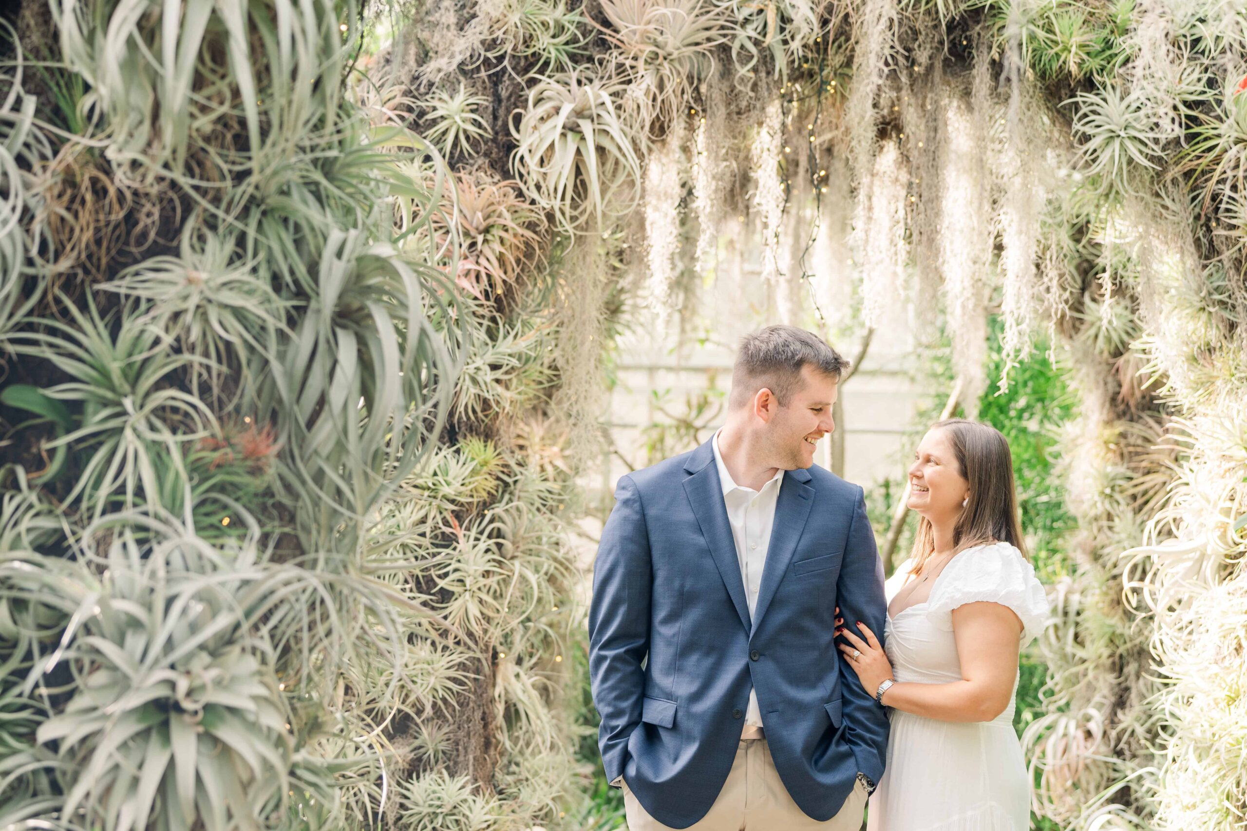 Engagement photographer capturing couple in orchid conservatory