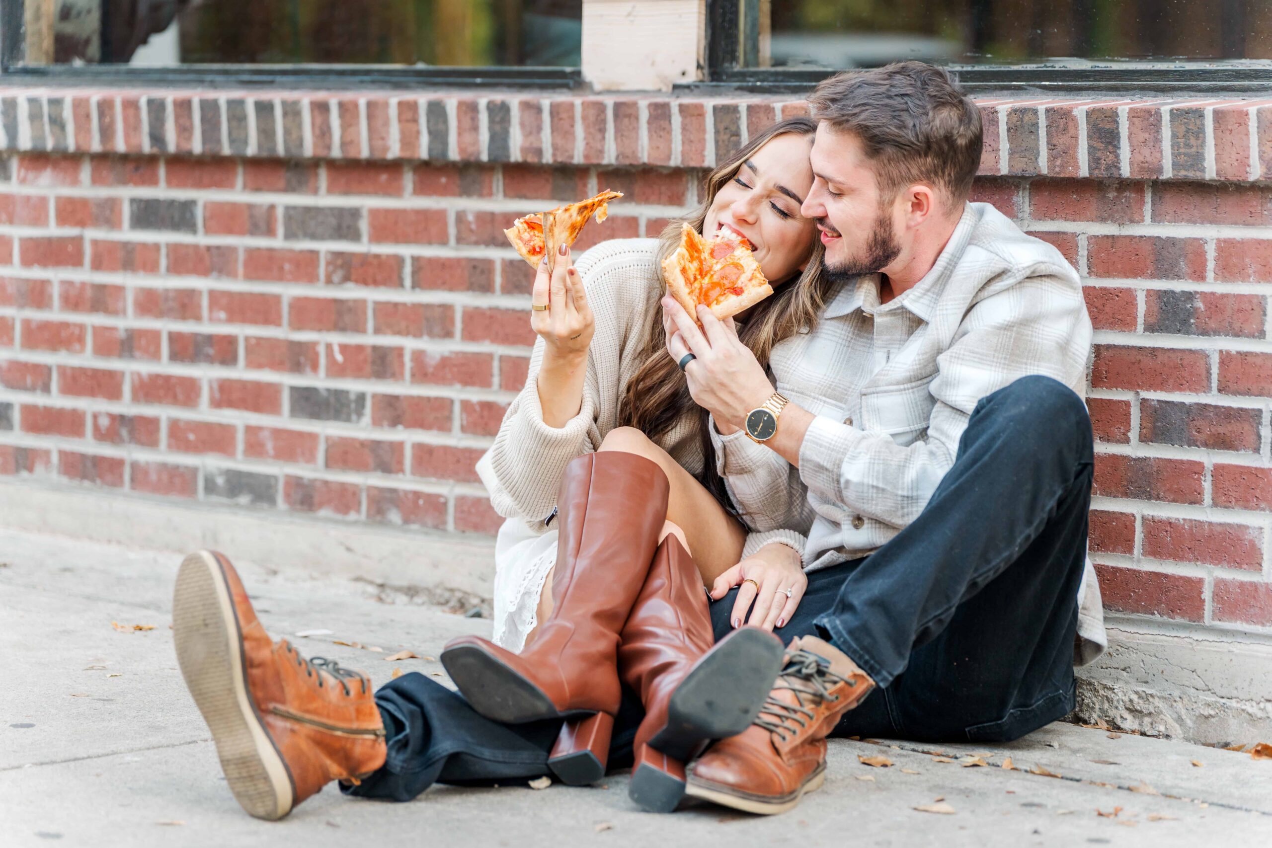 Candid engagement photo of couple sharing pizza in French Quarter alley
