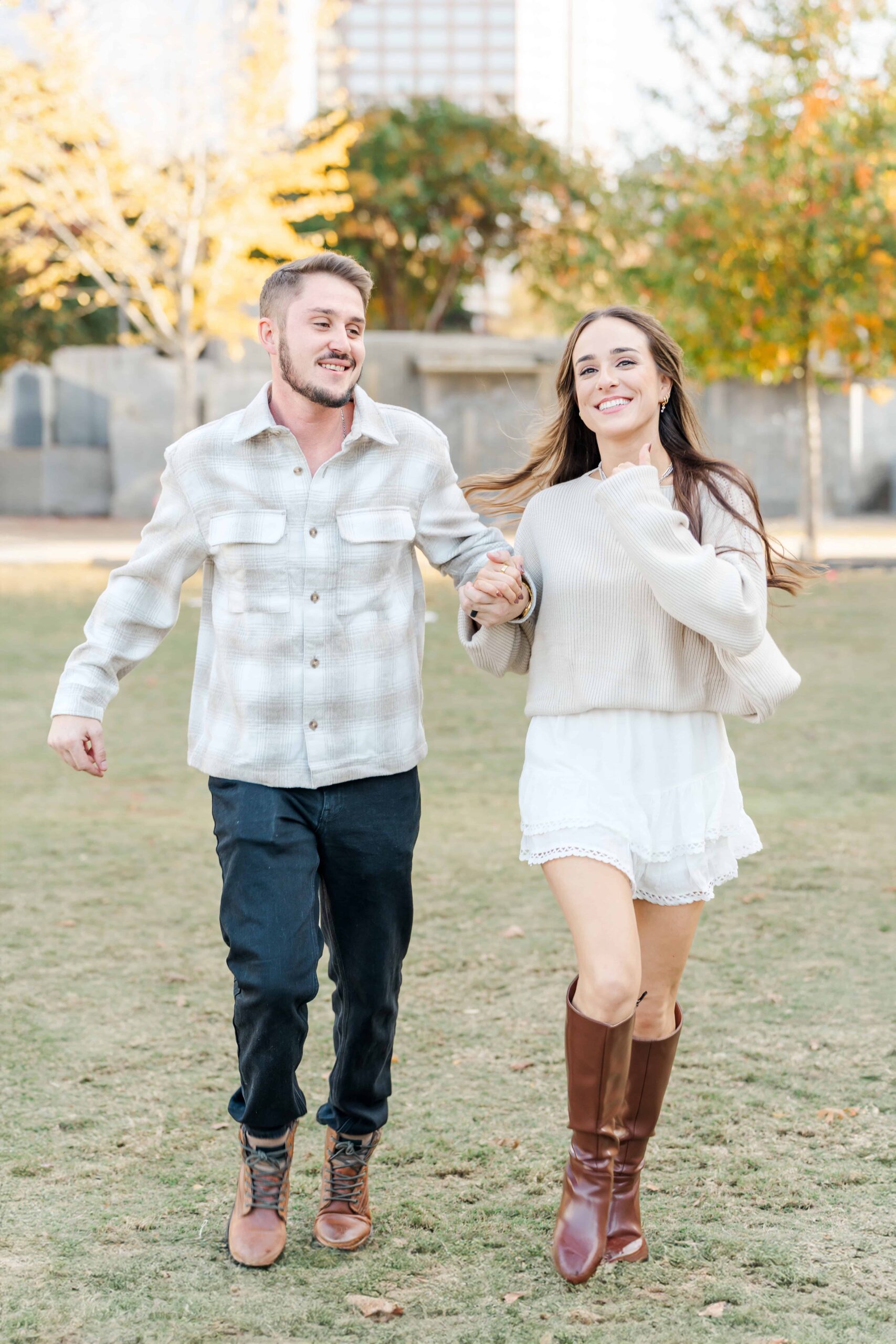 Close up engagement portrait with Charlotte NC skyline nearby