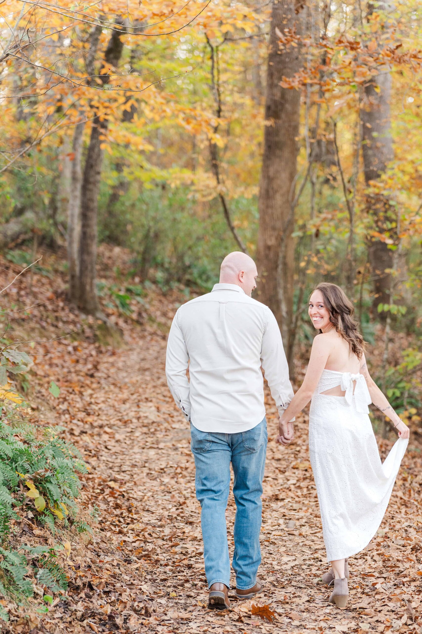 Romantic moment in nature with couple surrounded by tall trees in Charlotte