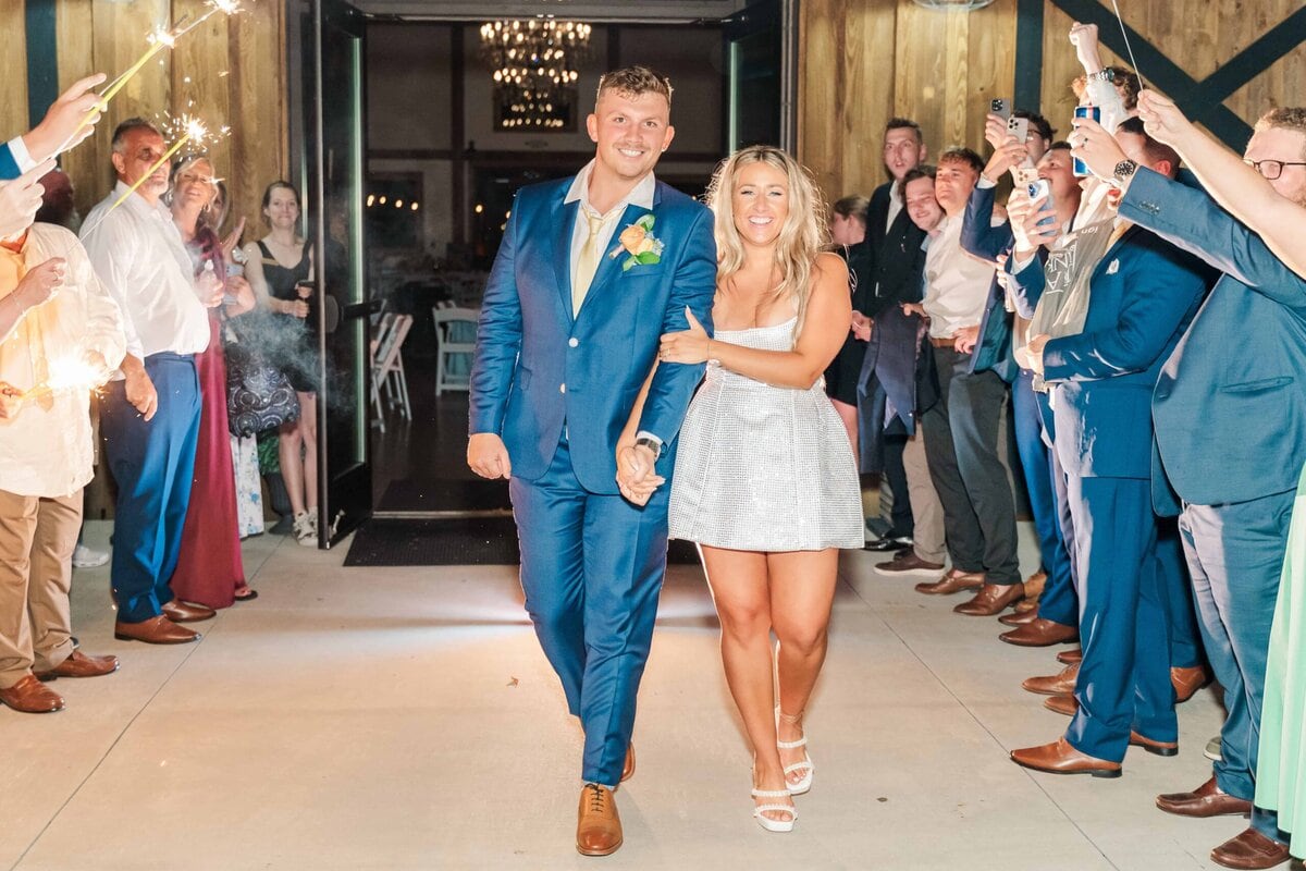Bride and groom walking through sparklers at Camelot Meadows Event Venue